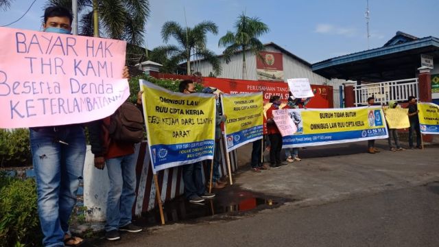 Pendemo membawa poster dan spanduk di depan pabrik PT. SGS Jombang. (wacananews.co.id)